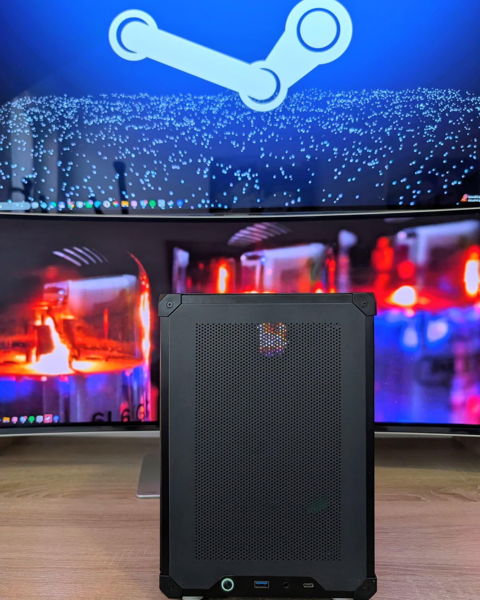 Kompaktní herní počítač SFF Machine před monitorem se Steamem
